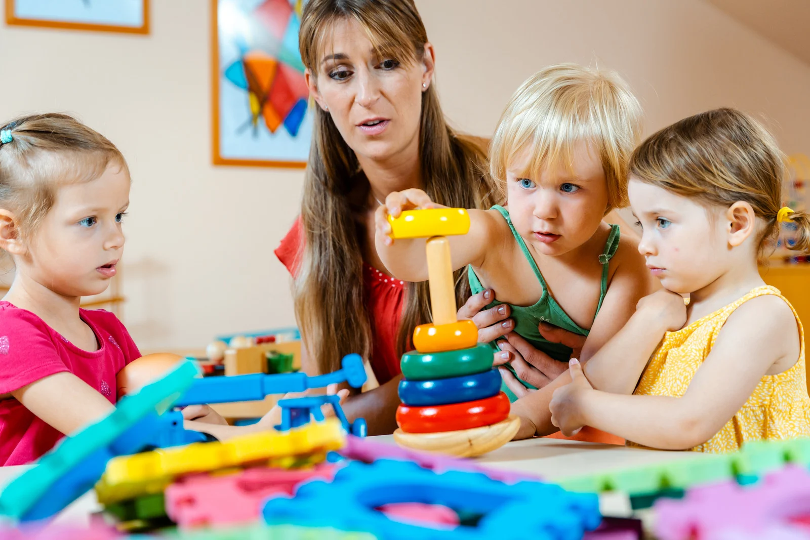 A happy child playing in a colorful daycare center with toys and other children