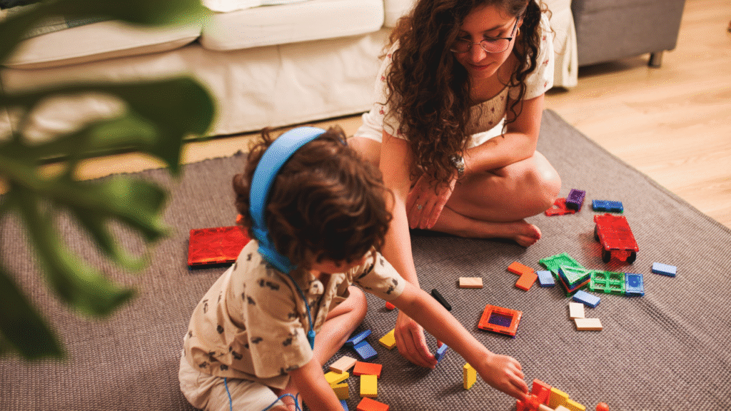 A joyful toddler playing with building blocks on a colorful mat (2)